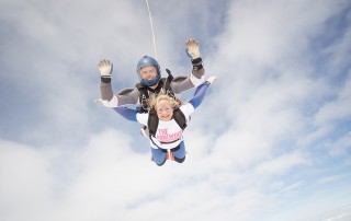 Cubicle Centre's Rachel Stanley tandem skydiving in a cloudy sky