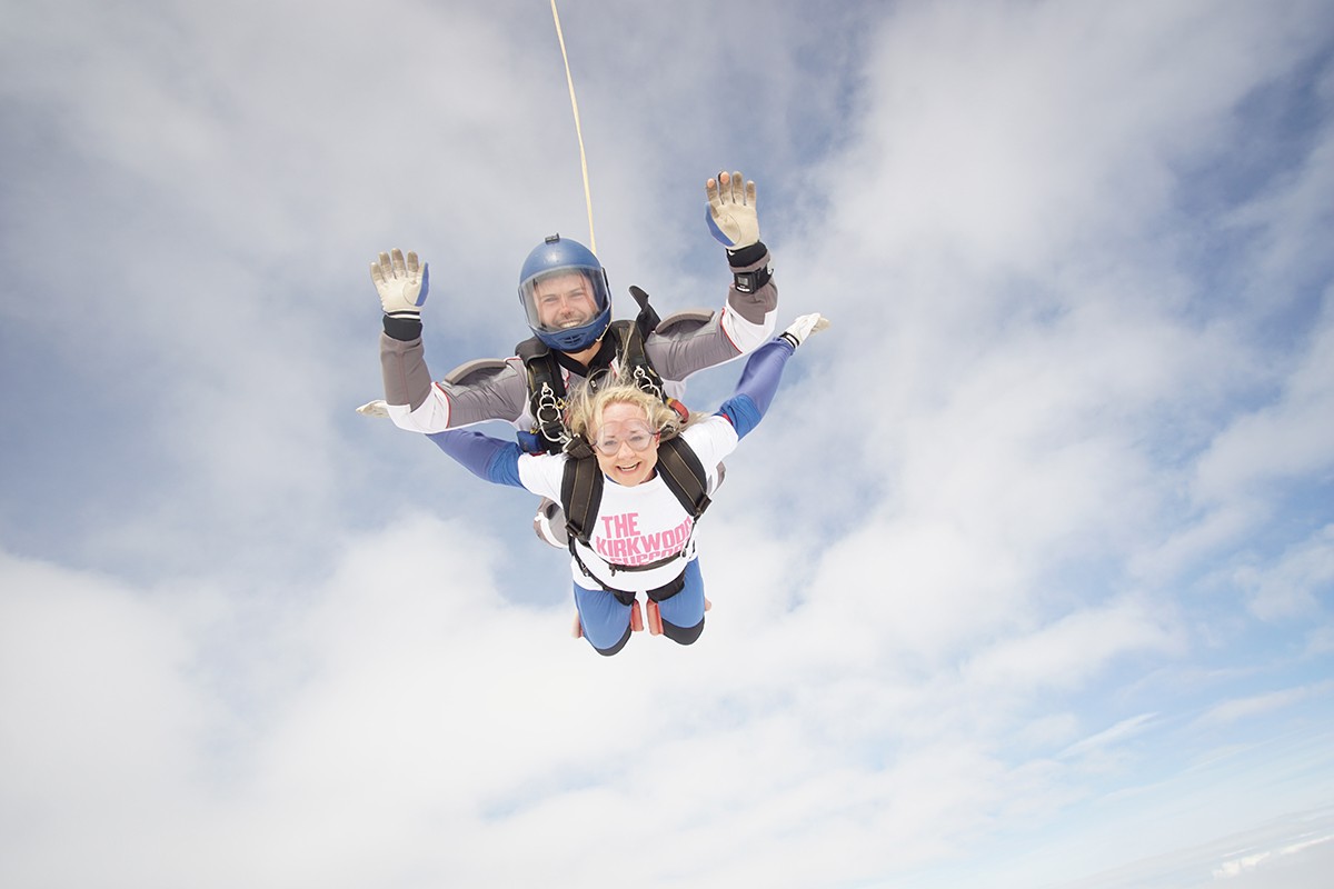 Cubicle Centre's Rachel Stanley tandem skydiving in a cloudy sky